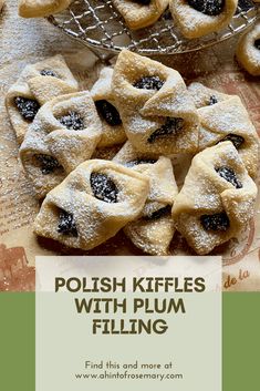 polish kiffles with plum filling on a table next to a bowl of powdered sugar