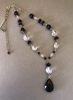 This pretty silver tone wire strung mixed black and clear faceted and variegated Lucite bead necklace is 23 inches long with a front decorative drop that is 2 3/8 inches long. The largest black teardrop front bead is 20mm tall and 15mm wide and the larger round aurora borealis beads are 13mm. This is classic timeless closet basic necklace. It has a sturdy lobster claw and chain closure. I specialize in finding fun wearable jewelry. Please browse my shop for more options. I box jewelry sales in n Jewelry For Black Dress, Silver Drop Jewelry With Faceted Beads, Silver Drop Necklaces With Faceted Beads, Silver Teardrop Necklace With Faceted Beads, Silver Teardrop Crystal Necklace With Faceted Beads, Diy Jewelry Projects, Bracelet Craft Diy, Lace Necklace, Wire Necklace