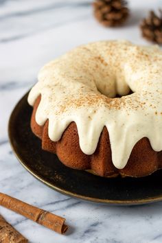 a bundt cake with white icing and cinnamon sticks