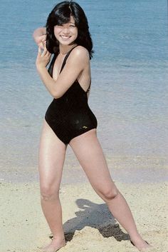 a woman in a bathing suit standing on the beach