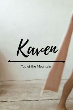 a woman standing in front of a white wall with the words kaven top of the mountain