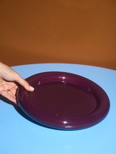 a purple plate being held by a person's hand