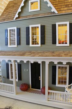 a doll house with furniture and decorations on the front porch