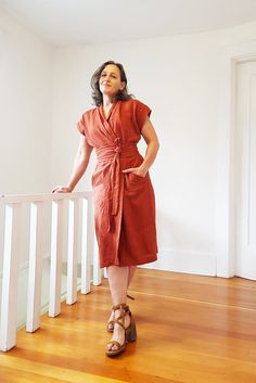 a woman in a red dress is standing on the stairs