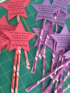 some pink and purple paper stars on top of a cutting board with words written on them