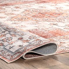 an area rug on the ground with wood flooring and wooden floors in front of it