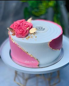 a pink and white cake with flowers on top