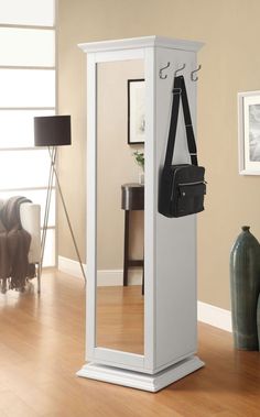 a mirror with a bag hanging from it's side in front of a chair