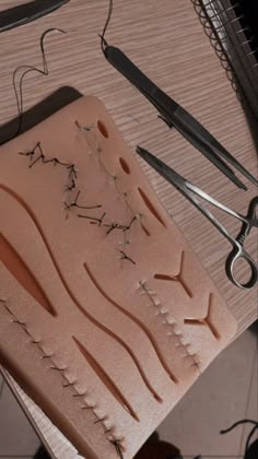 some scissors are laying on top of a cutting board