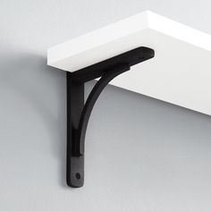 a black and white shelf mounted to the side of a wall