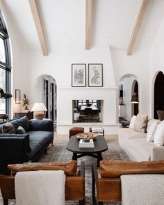 a living room with couches, chairs and a fire place in the middle of it