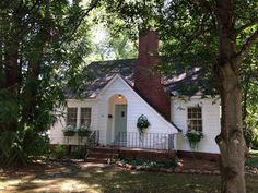 a white house surrounded by trees and greenery