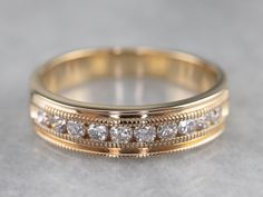 This vintage ring is utterly timeless, a glittering confection of milgrain details and diamonds! Wear this as a wedding band or anniversary gift, or add it to a stacking set for a little sparkle. Metal: 14K Yellow Gold Gem: 10 Diamonds totaling .35 Carats, VS in Clarity, G in Color Width of Band: 4.9 mm Height off Finger: 1.9 mm Ring Size: 7.75 Marks: "14K" Stamped on the inside band Elegant Gold Bands With Channel Set, Formal Yellow Gold Bands Channel Set, Formal Yellow Gold Channel Set Bands, Timeless Yellow Gold Channel Set Diamond Ring, Timeless Yellow Gold Channel Set Rings, Vintage Diamond Wedding Bands, Wedding Bands For Her, Gold Diamond Band, Diamond Jewel