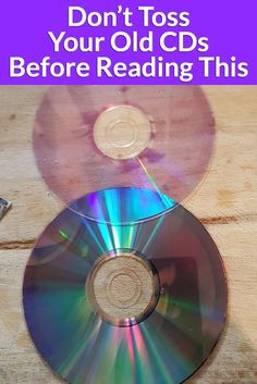 two cds sitting next to each other on top of a wooden table with the words don't toss your old cds before reading this