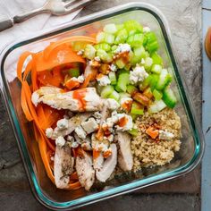 a glass container filled with rice, meat and veggies on top of a table