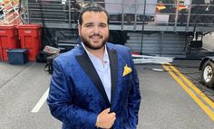 a man wearing a blue suit and bow tie standing in front of a stage set