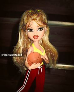 a close up of a doll with a basketball in her hand and wearing red pants