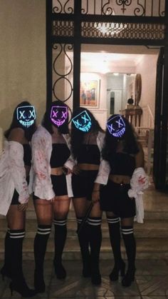 the girls are dressed up in costumes and have glowing masks on their faces for halloween