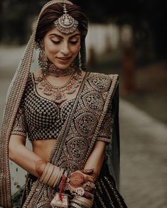 a woman in a bridal outfit with jewelry on her neck and hands behind her back