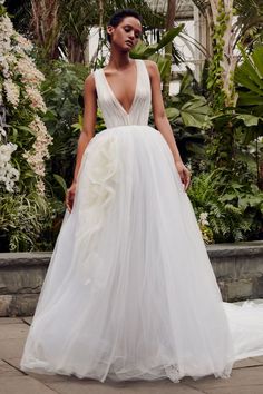 a woman in a white wedding dress standing outside