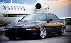 a black car parked in front of an airplane