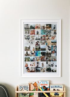 a book shelf filled with books next to a white wall and framed pictures on the wall