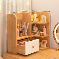 a wooden desk topped with drawers filled with cosmetics and personal care items next to a mirror