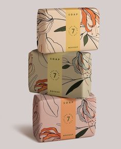 three soap bars stacked on top of each other in different colors and designs, one with an orange flower