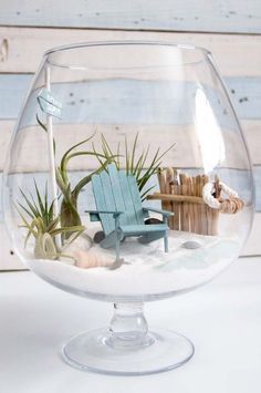 a glass bowl filled with sand and air plants