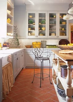 a kitchen filled with lots of white cabinets and counter top space next to a dining room table