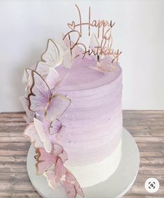 a purple and white cake with butterflies on it