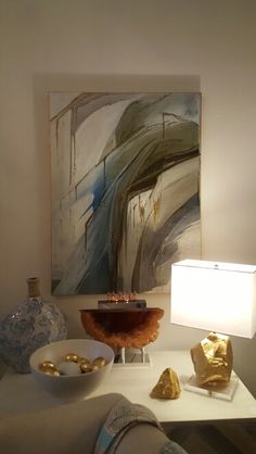 a living room filled with furniture and a painting on the wall above it's coffee table