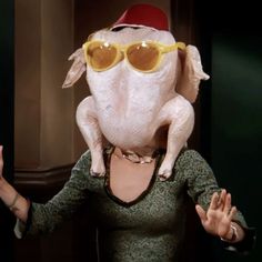 a woman wearing sunglasses and a pig head in front of a mirror with her hands out