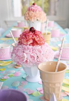 a table topped with vases filled with pink flowers