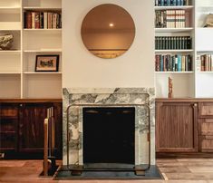 a living room filled with furniture and a fire place in front of a book shelf