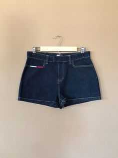 "High waisted 90's denim shorts. Made by Tommy Hilfiger in dark blue wash with classic Tommy Hilfiger logos. Shorts are in excellent clean condition with little signs of previous wear. Logos are still bright and crisp in color. Measurements (taken zipped or buttoned up and laid comfortably flat) inches x 2 for total circumference (inches) Tag Size 9 Tommy Hilfiger 100% Cotton ~Measure Rise First~ Waist 31\" Hips 40\" Length 12\" Inseam 2\" Rise 11\" Bottom leg circumference 24.5\" All items are 90s High Rise Jean Shorts For Summer, 90s High Rise Shorts For Summer, 90s Style High Rise Dark Wash Jean Shorts, 90s Style Denim Jean Shorts, 90s Style Jean Shorts For Summer, 90s High Rise Dark Wash Jean Shorts, 90s High Waist Jean Shorts For Summer, 90s Style Dark Wash Jean Shorts, 90s Style Dark Wash Summer Bottoms