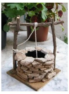 a stone fire pit sitting on top of a table next to a potted plant