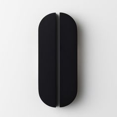 a black object on a white surface with one piece cut out and the other half closed