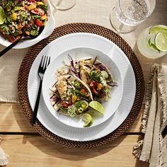 two plates of food on a table with glasses and utensils next to them