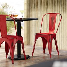 two orange chairs sitting next to each other near a table