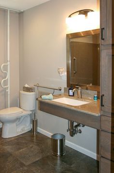 a white toilet sitting next to a bathroom sink