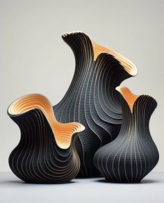 two black vases with wavy designs on the top and bottom, one is orange