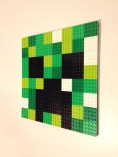 a green and black piece of art hanging on the wall