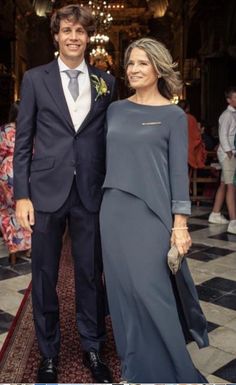 a man and woman in formal wear standing next to each other on a carpeted floor