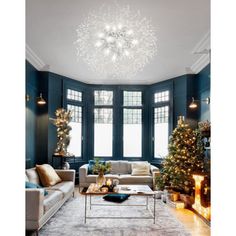 a living room filled with furniture and a christmas tree in front of a large window