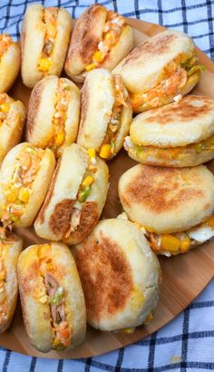 a plate full of mini sandwiches on a blue and white checkered table cloth,