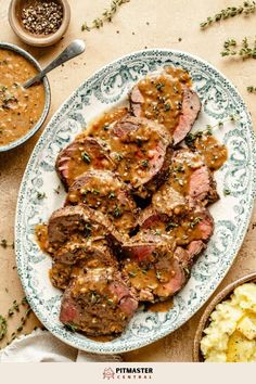 steak with gravy and mashed potatoes served on a blue and white plate