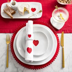 the table is set for valentine's day with heart napkins