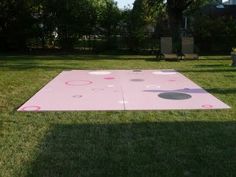 a pink area rug with circles and dots on it in the middle of a yard