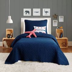 a bed with blue comforter and pillows in a room